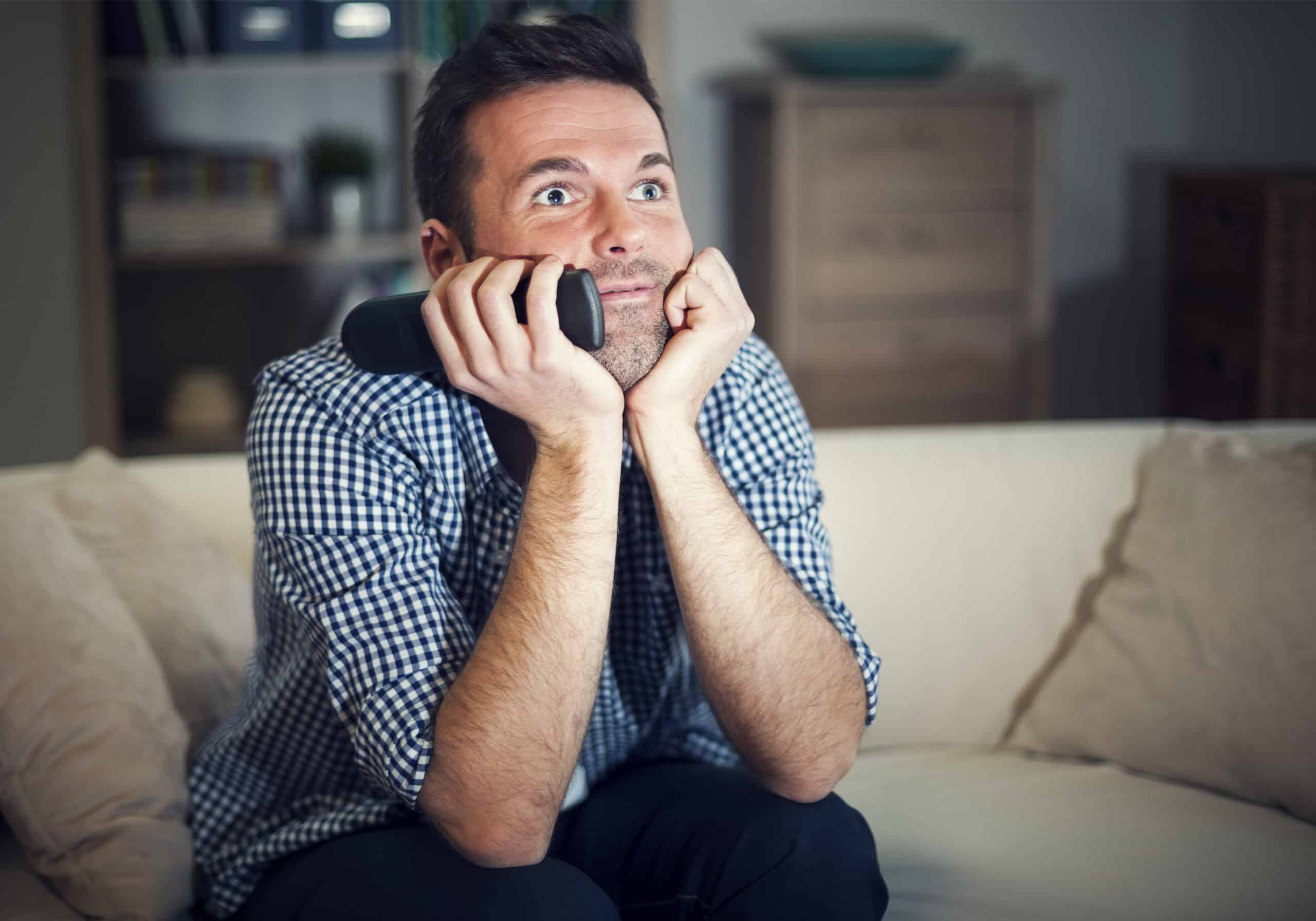 Smiling man watching interesting movie